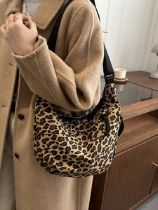 Close-up of leopard print canvas hobo bag with adjustable wide black shoulder strap