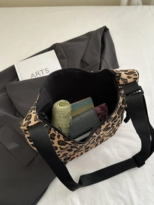 Detail of leopard print canvas bag interior showing large capacity for wallet and umbrella