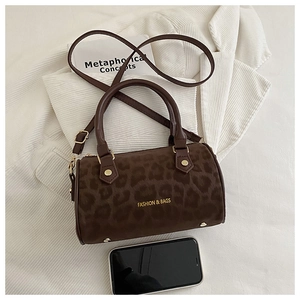 Detail of leopard print cylinder bag with gold lettering and adjustable shoulder strap