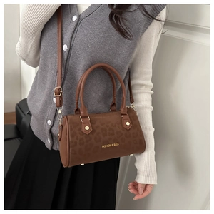 Chic leopard print Boston bag worn by a model showing the texture and strap detail