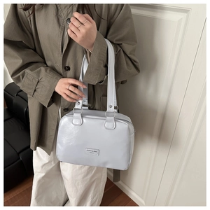 Close-up of light grey oil wax leather bag featuring silver metal ring strap connectors
