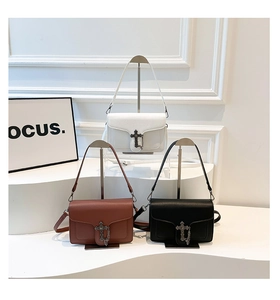 Detailed display of square chain bags with silver cross buckles in black, white, and brown