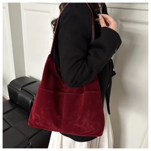 Dettaglio della borsa tote in pelle scamosciata bordeaux con due tasche frontali e design sobrio