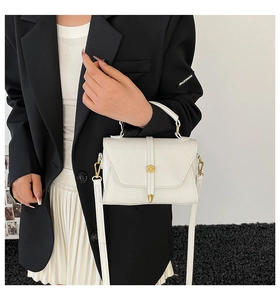 Dettaglio della borsa bianca in pelle con motivo litchi e hardware dorato sul modello