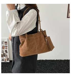 Detail of brown suede tote bag featuring white contrast stitching and a side coin pouch