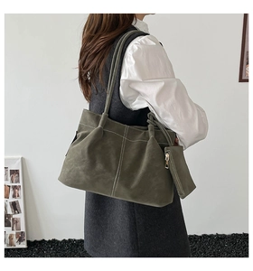 Detail of olive green suede tote bag featuring white contrast stitching and mini pouch