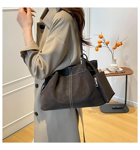 Detail of suede tote bag with white contrast stitching and matching mini pouch