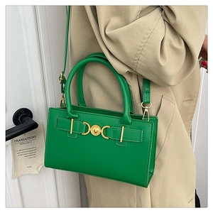 Dettaglio borsa a mano verde in pelle PU con una grande fibbia in metallo dorato a cuore