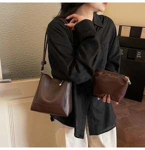 Macro shot of a dark brown faux leather bucket bag set with matching zip pouch