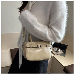 Detail of beige glossy leather crossbody bag with buckle and adjustable strap