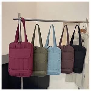 Detailed display of colorful quilted nylon tote bags on a display rack for winter 2025