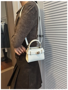 Détail d'un sac à main en cuir blanc avec fermoir doré CD et bandoulière réglable