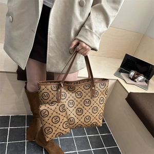 Brown monogram tote bag set with matching coin purse in a lifestyle office setting