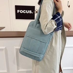 Light blue quilted nylon tote bag for laptops, minimalist winter style with front flap pocket