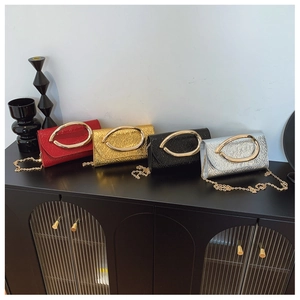 Close-up of snake skin evening bags with golden oval buckles and chain straps