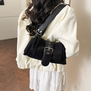 Sac bandoulière noir mat rétro avec large sangle et boucle argentée porté par un modèle