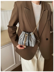 Detail of tweed mini bucket bag featuring gold chain and pearl drawstring charms