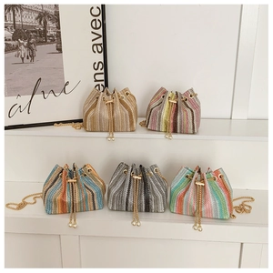 Detail showing five colorful woven bucket bags with gold chain straps and pearl drawstrings