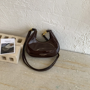 Elegant dark coffee patent leather crescent shoulder bag with glossy finish and gold buckle