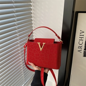 Red leopard embossed leather handbag with gold V hardware and crossbody strap