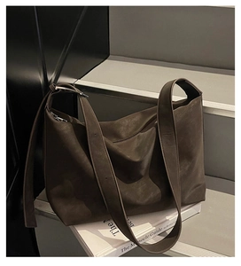 Détail du sac cabas en cuir mat marron foncé avec large bandoulière et boucle métal