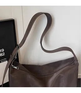 Détail de la longue bandoulière réglable sur un grand sac cabas vintage marron foncé