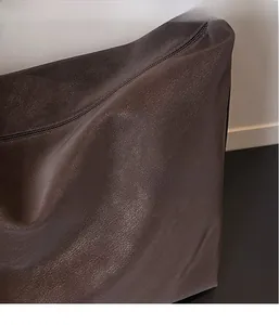 Gros plan sur la texture cuir grainé et la fermeture éclair en métal du sac marron foncé