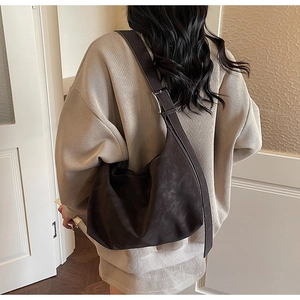Détail du sac hobo marron foncé avec texture mate et boucle métallique réglable