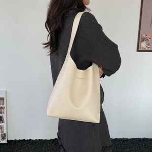 Sac à bandoulière beige minimaliste avec imprimé fashion porté par un mannequin