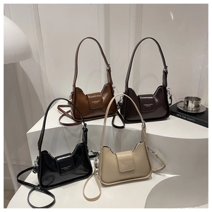 Detail view of four leather underarm bags in various colors on geometric stands