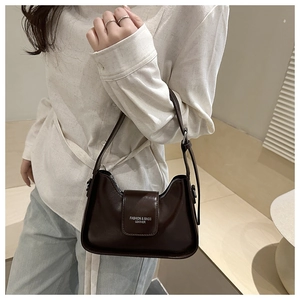 Detail of dark brown leather underarm bag with metal buckle and adjustable strap