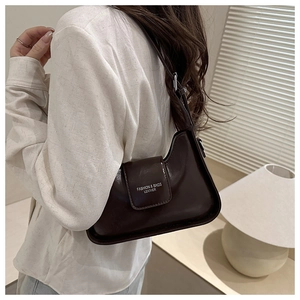 Close-up of dark brown gloss leather underarm bag with adjustable shoulder strap and logo