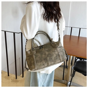 Detailed side view of a vintage dark green hobo bag with aged leather texture on model
