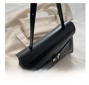 Detail of black leather crossbody bag featuring silver turn-lock and premium stitching
