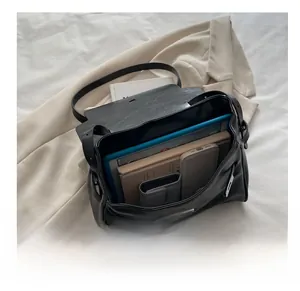 Macro shot of large capacity black leather shoulder bag with tablet and books inside