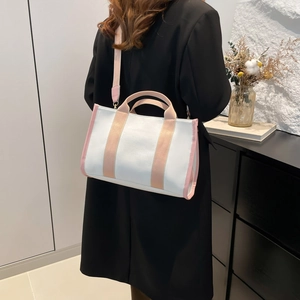Minimalist canvas tote bag with peach trim featuring a detachable shoulder strap