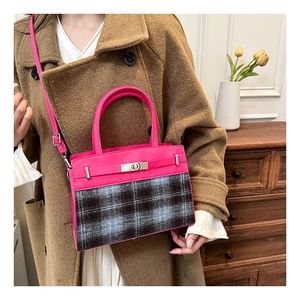 Détail du sac bandoulière en cuir rose et tissu à carreaux avec fermoir rotatif en métal