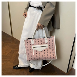 Lifestyle shot of large pink tote bag with bear print and white leather strap details