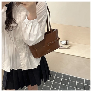 Detail of vintage brown oil wax leather shoulder bag with gold metal buckle decoration