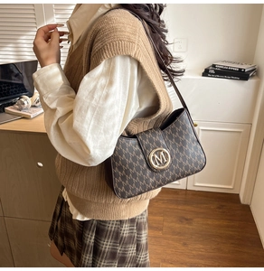 Detail of the brown monogram shoulder bag with gold metal buckle and leather strap