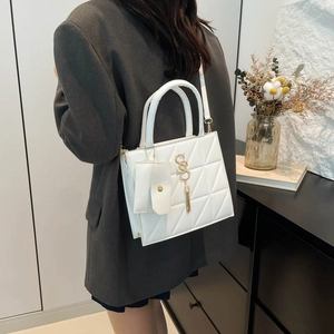 Sac à main blanc matelassé élégant avec logo doré porté par un mannequin en studio