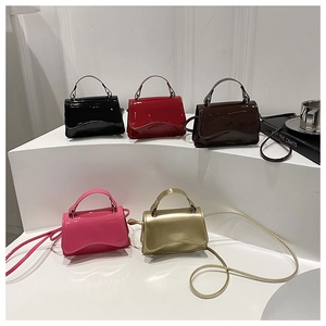 Macro shot of assorted mini glossy patent leather handbags with wavy flap detail