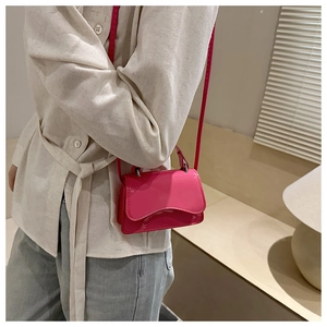 Close-up of fuchsia patent leather square bag with wave flap and glossy finish