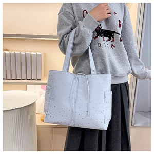 Detalle del bolso tote de lona azul claro con estrellas, bolsillos y cordón ajustable