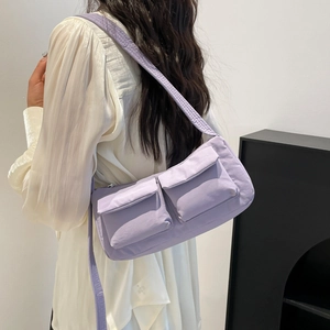 Light purple utility shoulder bag with dual front pockets and adjustable wide strap
