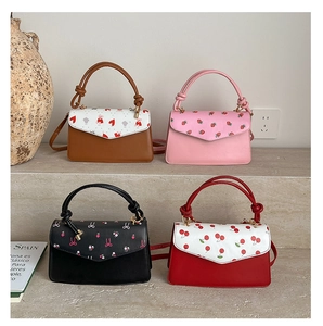 Detailed view of four colorful strawberry and floral pattern leather crossbody square bags
