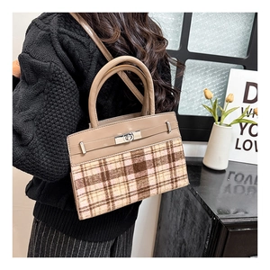 Détail de couture contrastée et motif à carreaux sur sac à main chic avec fermoir tournant