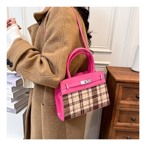 Dettaglio borsa a mano in tweed rosa e marrone con chiusura a scatto argentata e manico in pelle