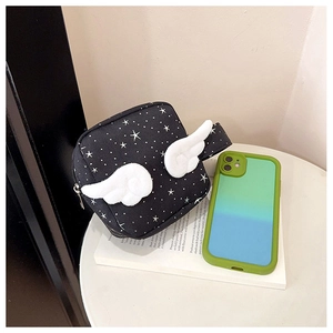 Dettaglio della borsa nera con motivo a stelle, ali in peluche 3D e chiusura a zip