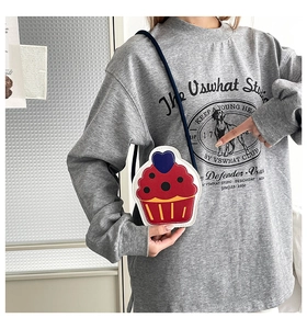 Model wearing a mini cupcake-shaped crossbody bag with red and white color blocking